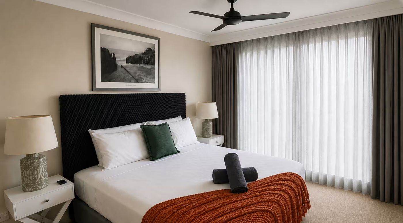 Bedroom 1 with a king bed, ceiling fan and sheer curtains